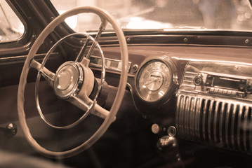 Blurred background - interior of a vintage car, styled as an old sepia photo with dust and...
