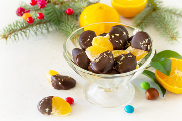 Slices of Tangerines in Chocolate. Dessert Tangerines on a stone or concrete background. Copy space.