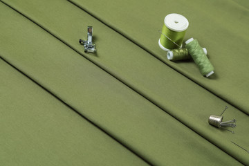 Monophonic fabric of green olive color a beautiful drapery folds on diagonal and decorated by coils...