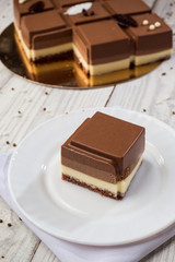Dark chocolate vegan cake with candies on wooden background