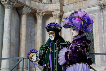 Colorful carnival lilac-green-black  mask and costume at the traditional festival in Venice, Italy