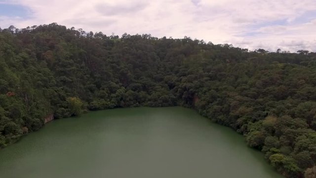Aerial drone reveal shot over a volcanic crater lake in Tacambaro, Mexico