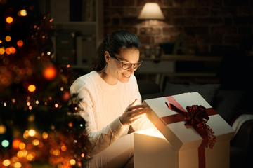 Woman opening a magical Christmas gift