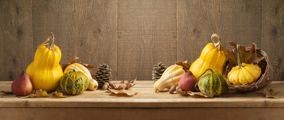Autumn harvest background with pumpkin and squash on wooden table