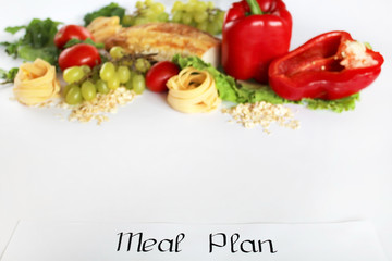 Obraz na płótnie Canvas A meal plan for a week on a white table among products for cooking - pastas, basil, vegetables, cereals and spices. Concept healthy eating, dieting, slimming and weigh loss concept, top view, flat lay