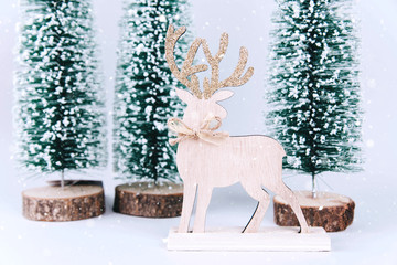 Christmas wooden tree with reindeer over light blue background.