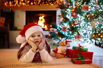 Child at Christmas tree. Kids at fireplace on Xmas