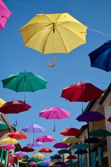 ombrelli colorati appesi sopra i tetti di una città