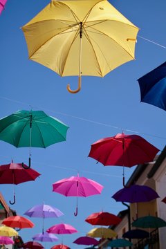 ombrelli colorati appesi sopra i tetti di una citt&agrave;