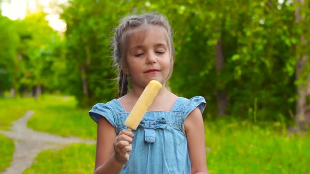 Girl eating popsicle ice-cream in park