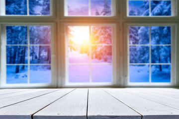 Wooden old table against the background of the window in winter sunset  