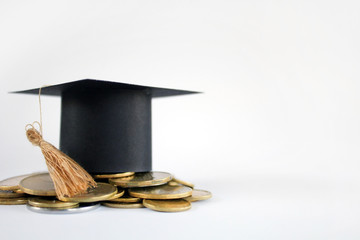 Graduation cap on saving coins for concept finance and education scholarships. Graduation...