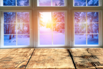 Wooden old table against the background of the window in winter sunset  