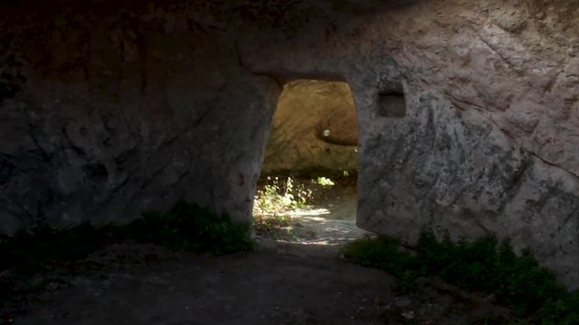 An ancient defensive structure in the rock, inside view. Shot. Natural entrance in cave. Cave house carved into the volcanic rocks with door