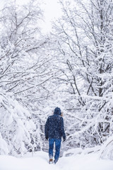 A man sneaks through the snow thickets. Winter forest and man. Winter.  Snowing