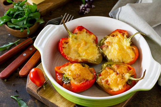 Stuffed peppers with turkey meat and cheese on a wooden table. Healthy food.