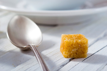 cup of tea, different leaves, honey, lemon ginger and brown sugar on white wooden table background