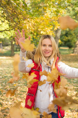 woman playing with colorful fall leaves