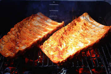 pork ribs on the grill cooking coals / fresh meat pork cooked on charcoal, summer home cooked meal, grilled ribs