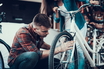 Man Fixes and Looks Attentively at Bike Brakes