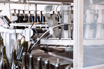 Glass bottles on the automatic conveyor line at the champagne or wine factory. Plant for bottling alcoholic beverages.