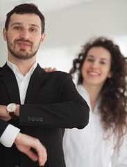Attractive stylish business people, team leader or manageress posing in front of a female colleague smiling confidently at the camera