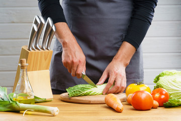 Woman use knife kitchen to chopped or cutting and sliced fresh cabbage on wood cutting board to...