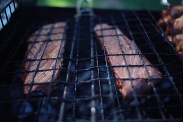 pork ribs on the grill cooking coals / fresh meat pork cooked on charcoal, summer home cooked meal, grilled ribs
