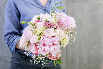 Woman holding bouquet of pink and yellow flowers.