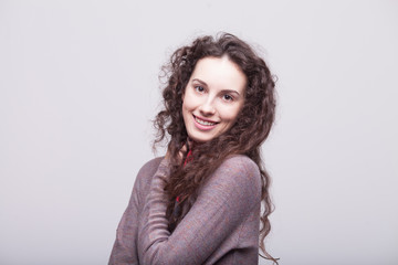 Obraz premium Glamour girl in dress on white. Woman with curly hair. Happy teacher. Warm dress. Smiling woman
