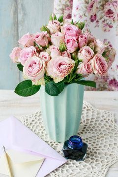 Bouquet of pink roses in ceramic vase.