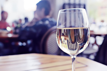 glass of white wine in the restaurant / white wine in the interior of the restaurant a table with glasses of wine, a romantic summer