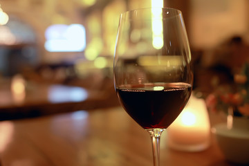 red wine glass serving / romantic dinner in the interior of the restaurant, a table served with a glass of grapes wine