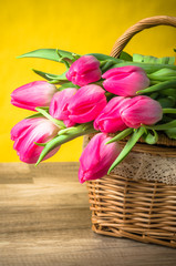 Fototapeta na wymiar Beautiful bouquet of pink tulips in a wicker basket