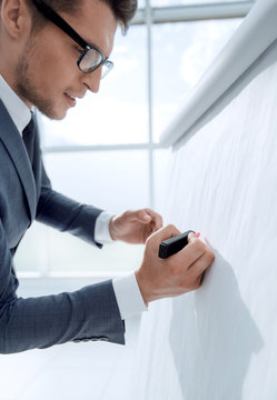 Handsome Mature Businessman Writing At Empty Flip Chart