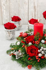 Christmas decoration with red roses, fir, brunia and cinnamon sticks.