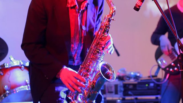 Saxophone player in jazz band performing on stage at holiday concert