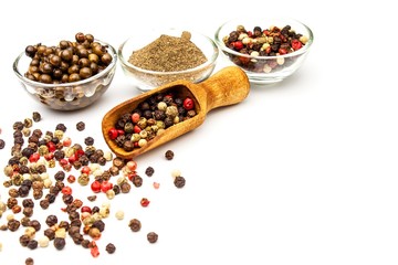 Pepper in wooden spoon. Mix of different peppers balls on white background. Sale of spices.