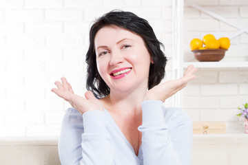 Smiling happy middle age woman with healthy natural teeth at home background. Skin care and anti...