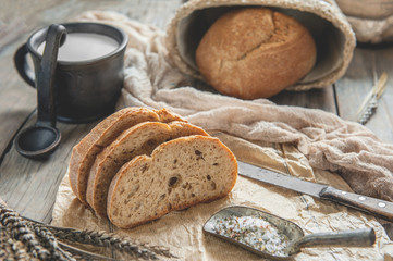 Naklejka premium A beautiful loaf of sourdough bread from white wheat on a plate on a linen edge. Homemade pastries
