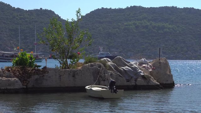Boat near the pier in the popular tourist spot of the village of Kekova on the Antalya coast of the Mediterranean Sea. Natural landscape with ships, sea, mountains and island