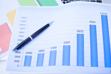 financial graph chart with notebook and black pen and keyboard. business concept