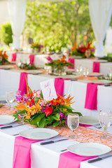 details of flowers, plates and glasses under outdoor tent wedding