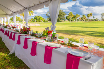 details of flowers, plates and glasses under outdoor tent wedding