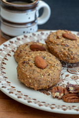 Almond Cookies on a antique plate with pecans and a cup of coffee
