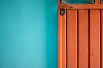 Orange steel door against blue wall detail