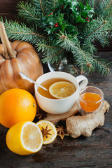 Cup of hot lemon tea with orange pumpkin and ginger jam on a wooden background. Healthy drink cold. Winter drink