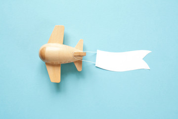 Children's wooden plane in the sky carries an empty banner.