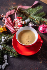 Obraz na płótnie Canvas Coffee espresso, red cup of coffee and Christmas decorations on dark background.