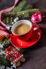 Coffee espresso, red cup of coffee and Christmas decorations on dark background.